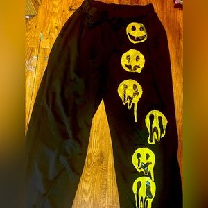 Cute black sweatpants with smiley faces on the left side.